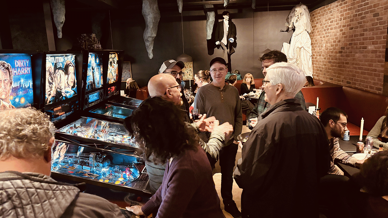 people having fun eating and playing pinball at the diner