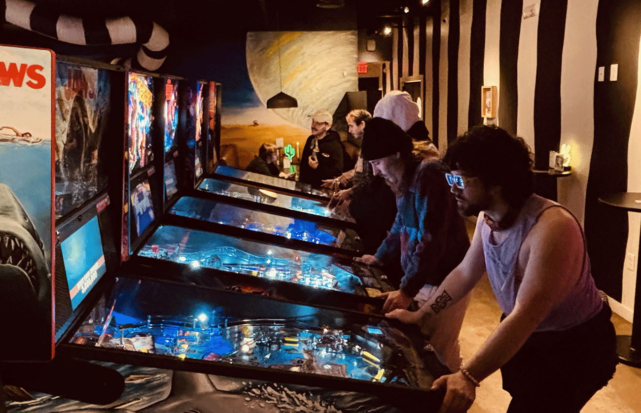 people having fun eating and playing pinball at the diner